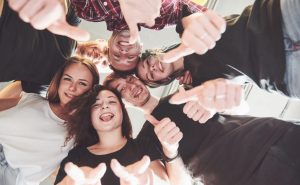 Happy group of friends with their hands together in the middle.
